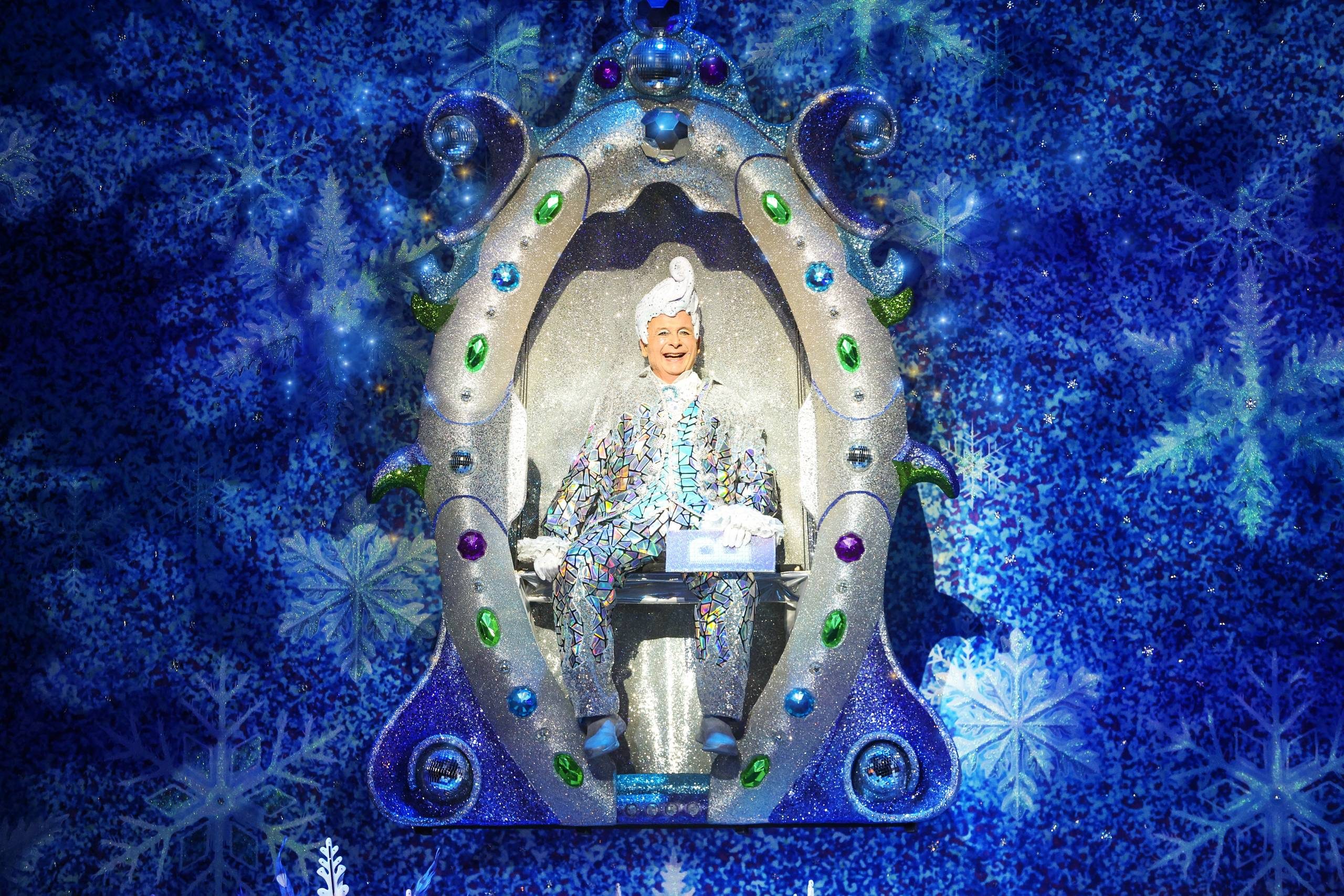 Snow White and the Seven Dwarfs Christopher Biggins sits in a sparkly mirror set with a blue snowflake background behind him
