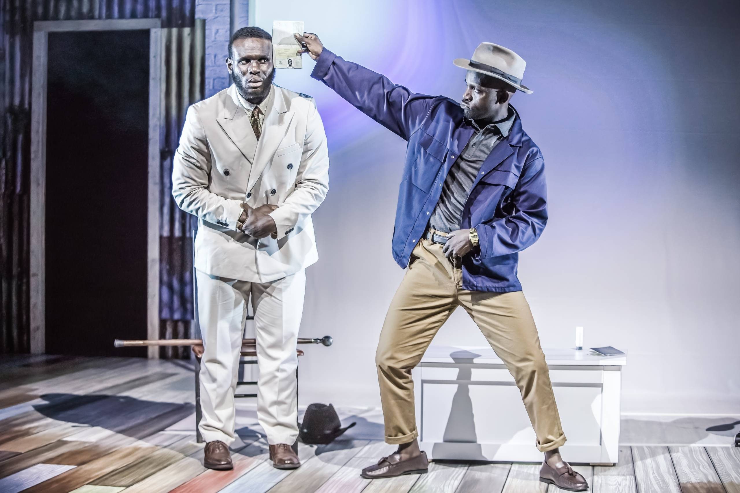 Sizwe Banzi Is Dead Two male characters, one holds a passport up to the others face.